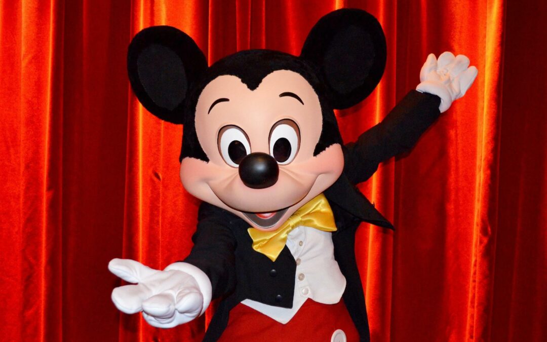 Photo de Mickey, devant un fond rouge, tendant la main vers le spectateur