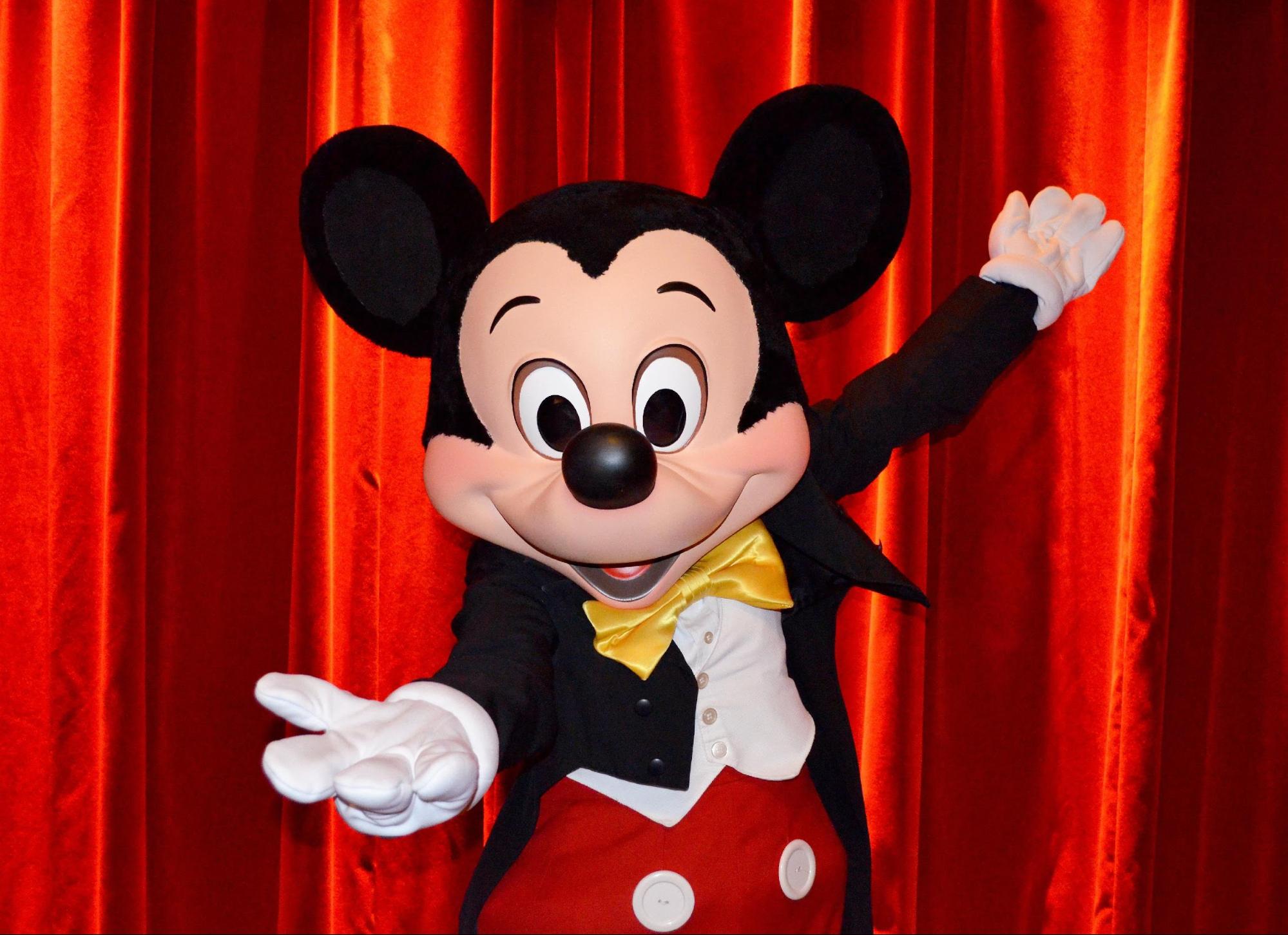 Disney Photo de Mickey, devant un fond rouge, tendant la main vers le spectateur