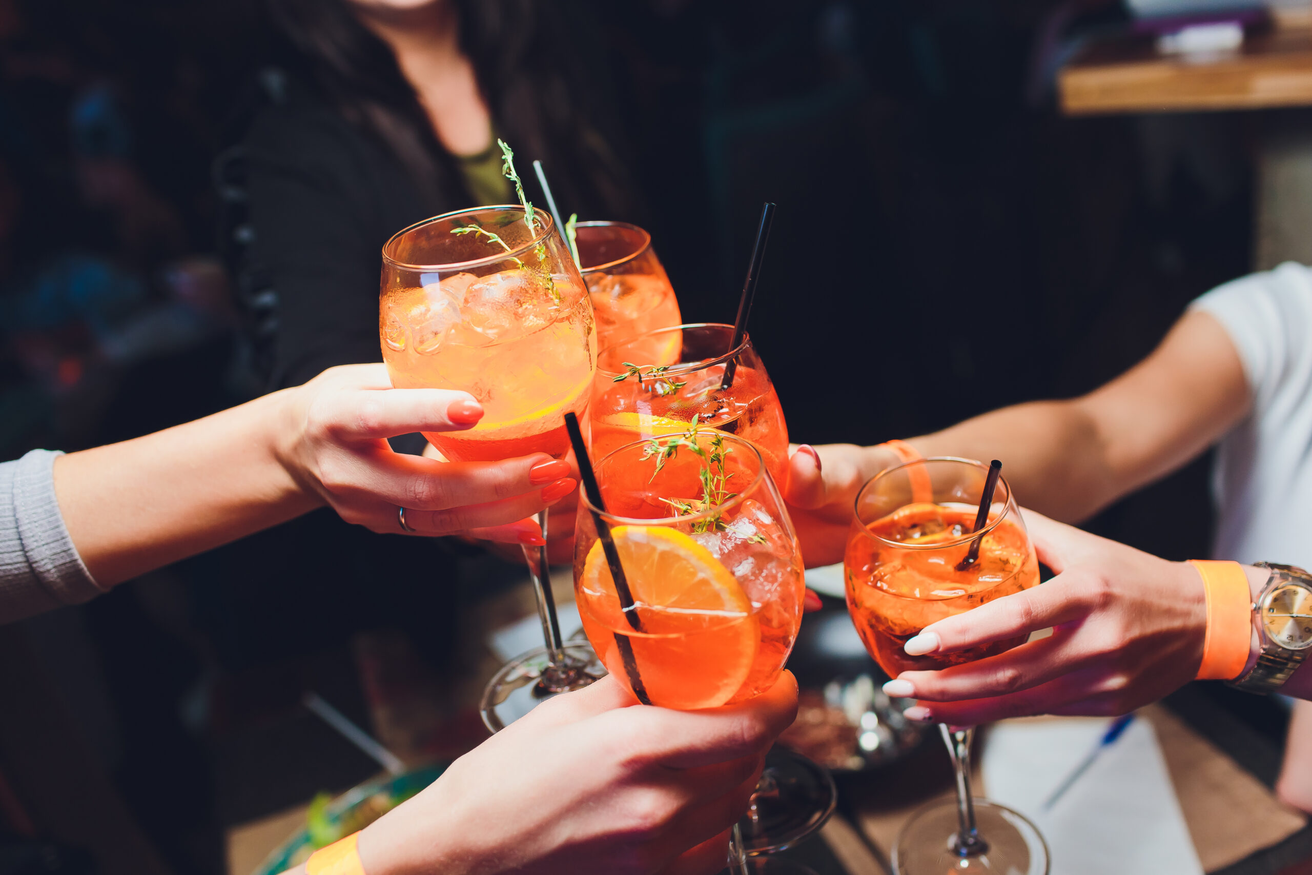 Photo de personne trinquant avec des cocktails Spritz